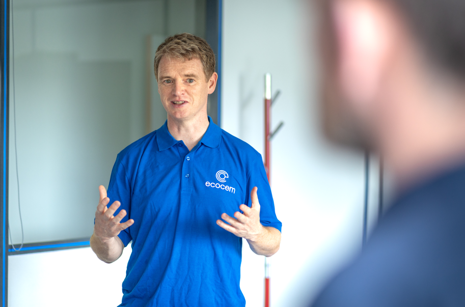 A man in a blue shirt holding his hands outright