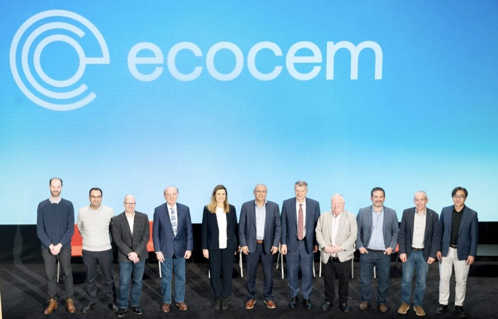 A group of people standing in front of a blue cinema screen which has the Ecocem logo on it.