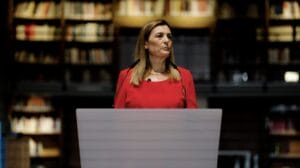A woman in a red dress giving a speech
